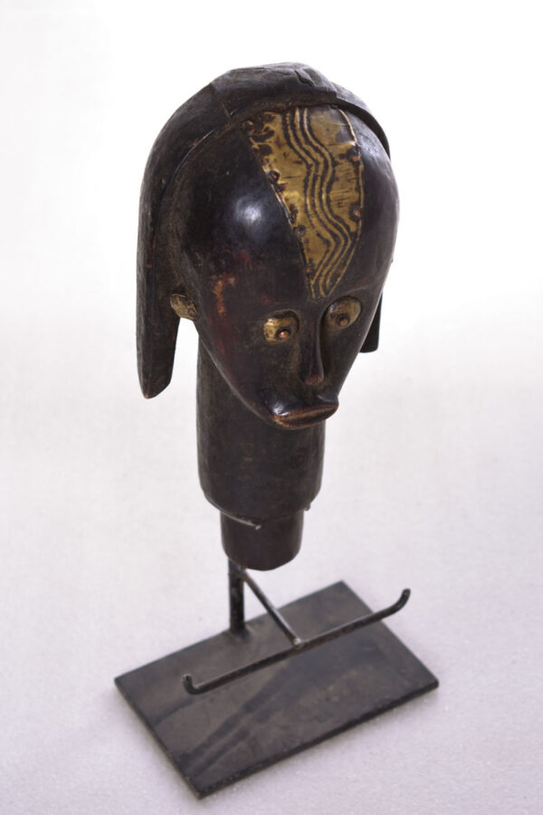 The wooden head is decorated with copper strips.